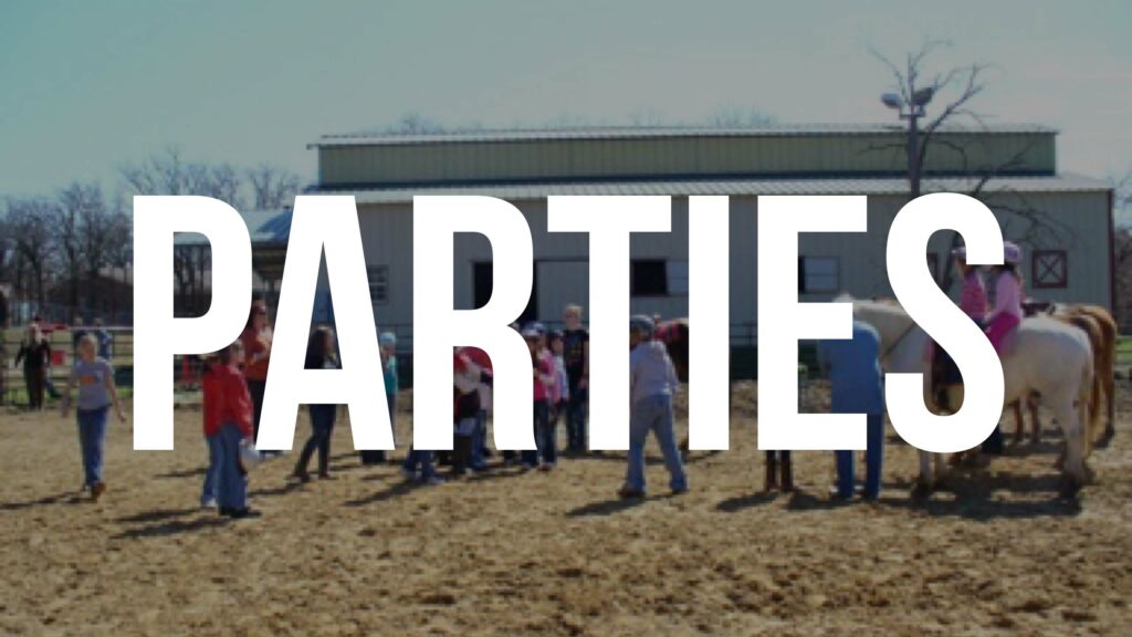 A group of people standing in the sand with a building behind them.