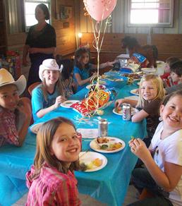 A group of children sitting at a table eating.