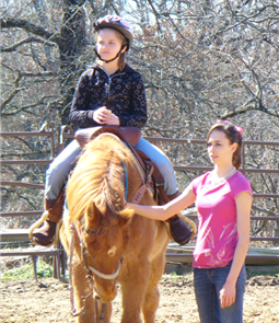 A woman and girl riding on the back of a horse.